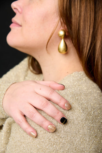 Hand met Black & Gold gel nagelstickers – combinaties van zwart en goud glitter