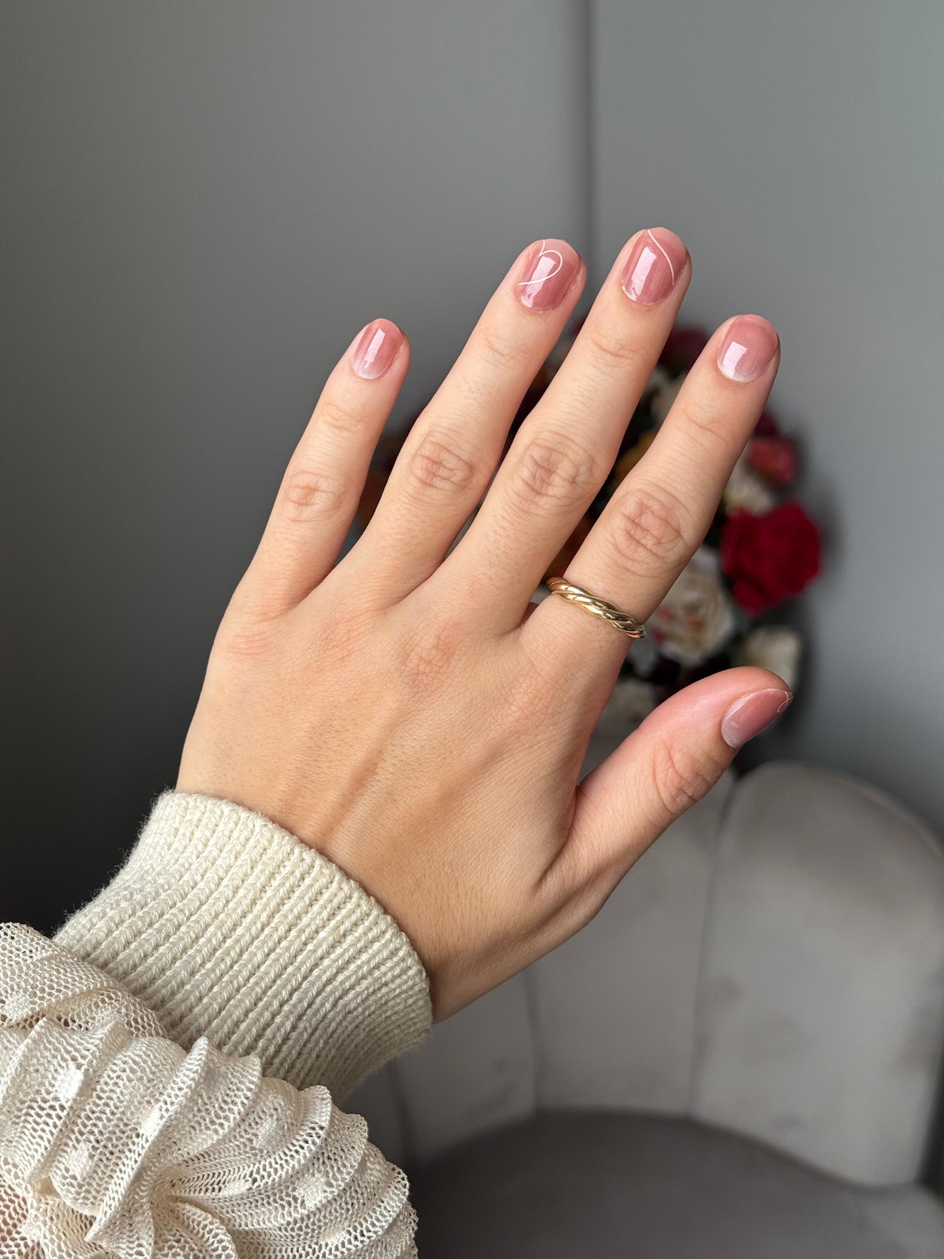 Hand met Touch of Love gel nagelstickers – zachte nude roze ombre met wit hartdetail
